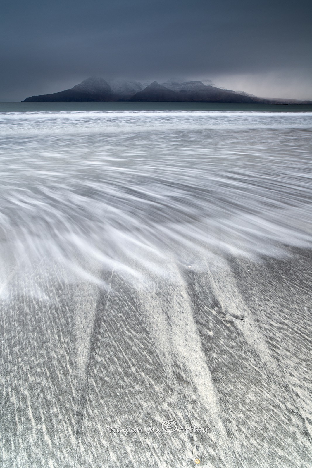 Dessins sur le sable et vue sur l'île de Rum depuis l'île d'Eigg