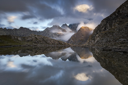 reflet dans le lac de Clot Sablé du mont Viso qui se cache dans la nebbia,