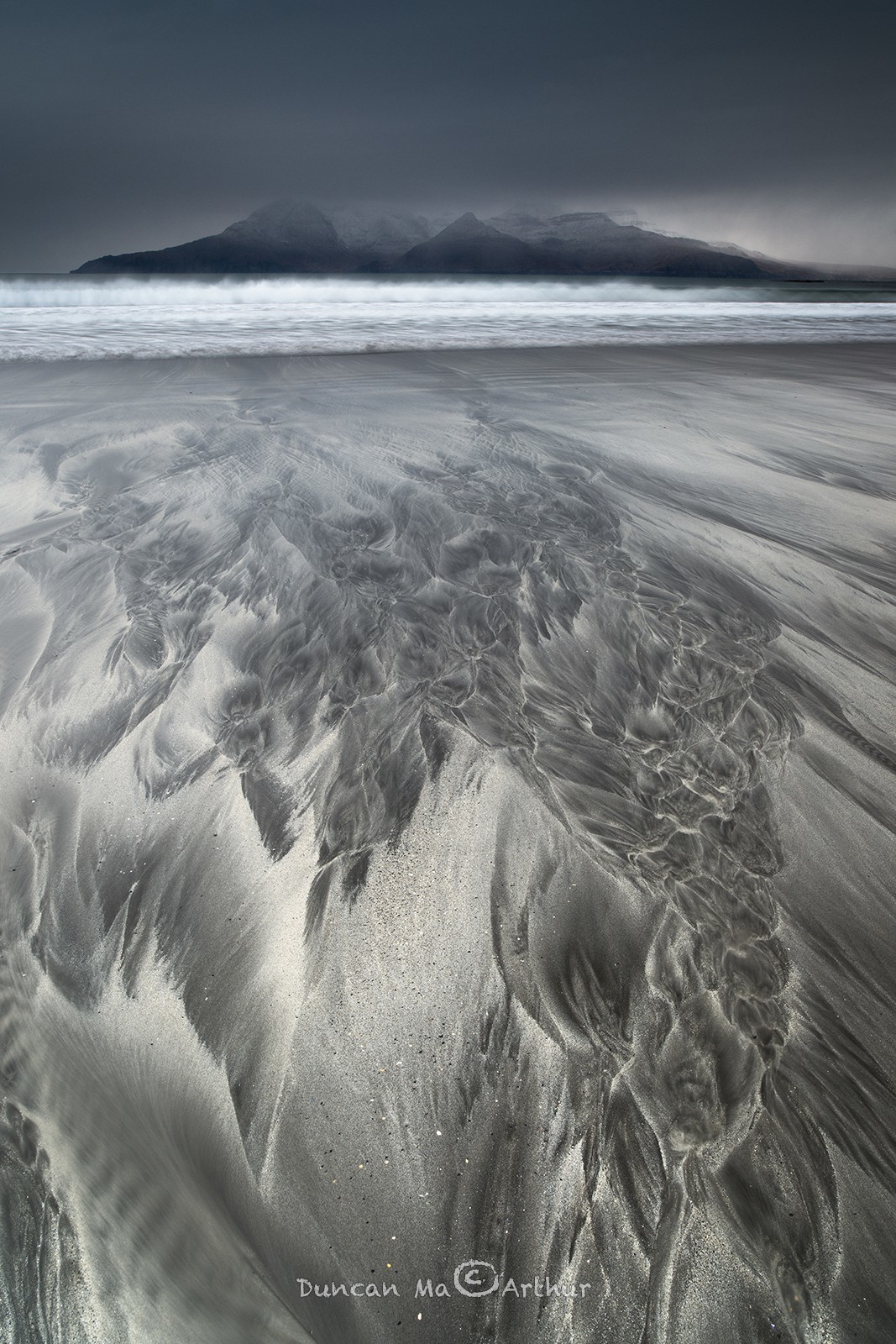 Dessins sur le sable et vue sur l'île de Rum depuis l'île d'Eigg